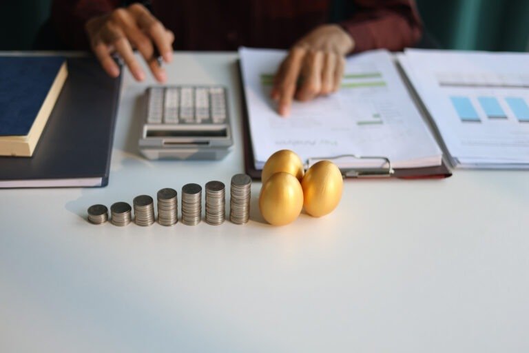 Rising stack of coins and golden eggs on the table. Businessman