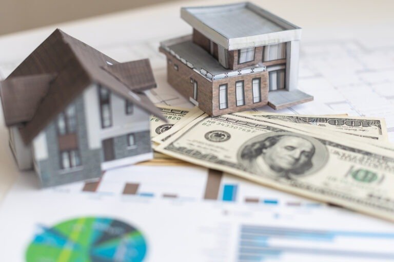 paper house model on background of US dollars banknotes. Housing market, purchase or rental of real estate