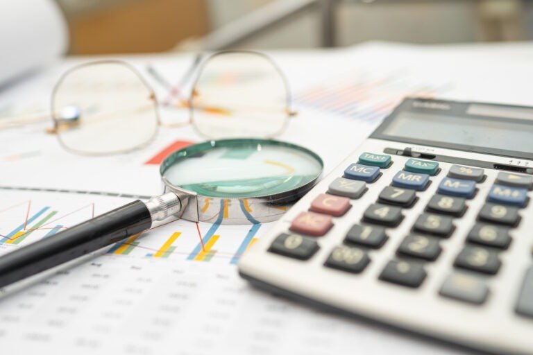 Calculator on chart and graph spreadsheet paper. Finance develop